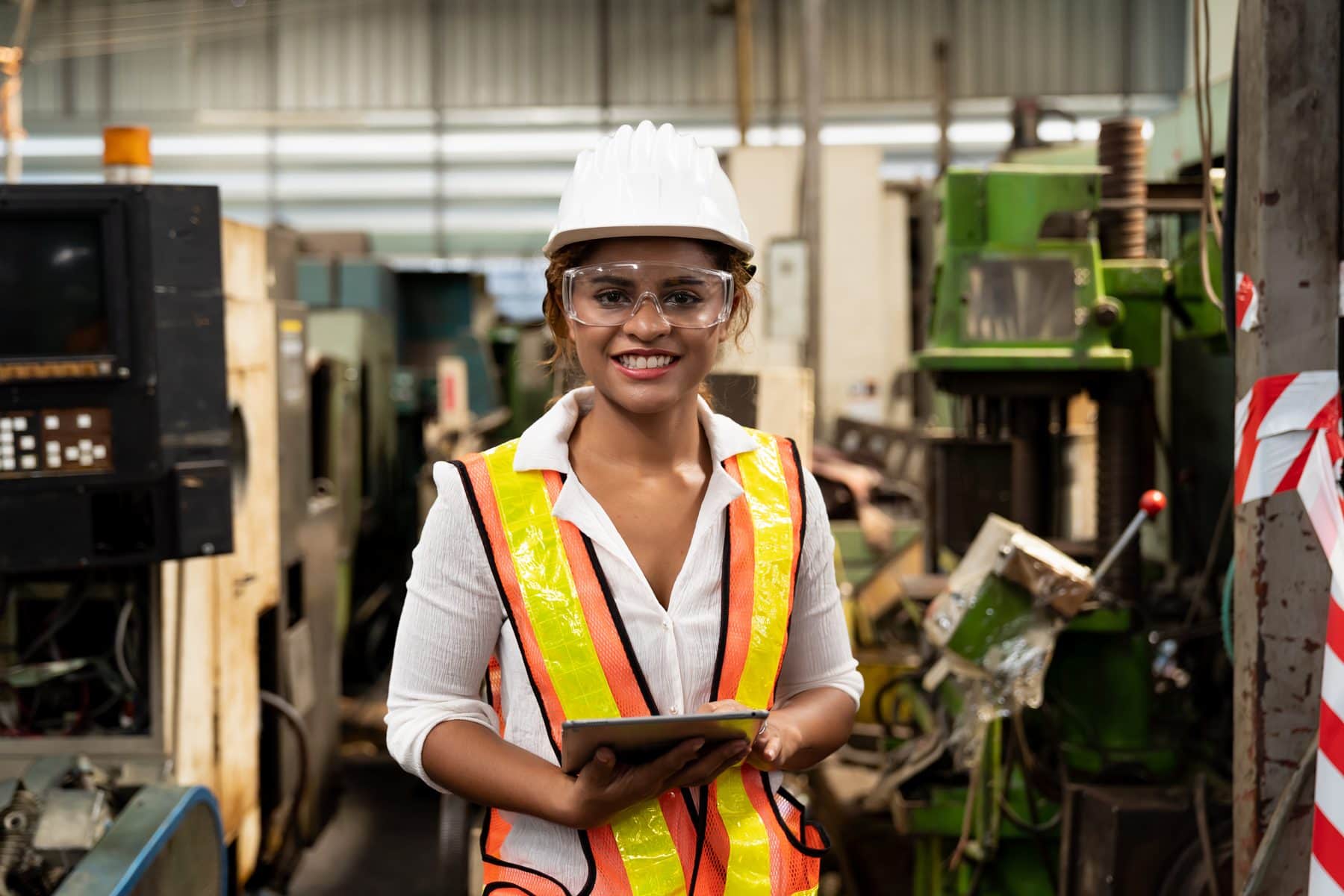 Manufacturing team member reviewing production data on a tablet on the plant floor